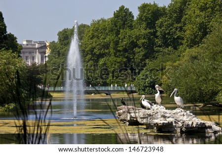 The Pelicans basking in the sunshine in St. James's Park, London.  Buckingham Palace is in the background. Royalty-Free Stock Photo #146723948