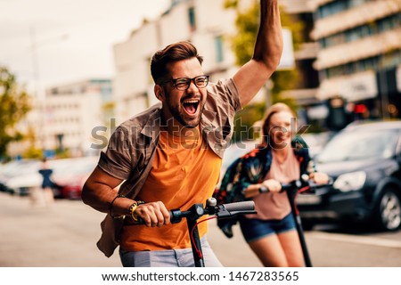 Young couple on vacation having fun driving electric scooter through the city.	 Royalty-Free Stock Photo #1467283565