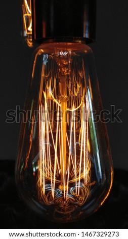 Incandescent lamp on a dark background. Decorative electricity in retro style for story
