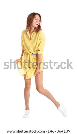 Beautiful young woman in yellow dress dancing on white background
