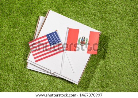 Paper box of pizza with flags of Peru and America on the grass. Concept of peace, partnership and friendship, . Top view