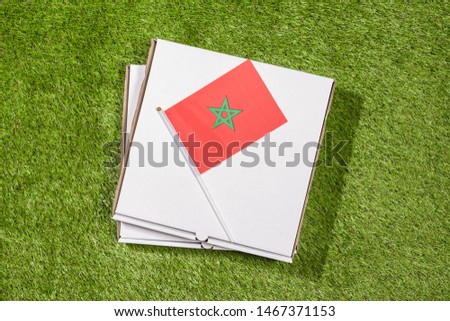 Paper box of pizza with iranian Morocco on the grass. Concept. Top view