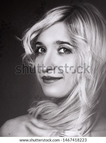 Blonde girl hair twisted around her neck. Black and white portrait