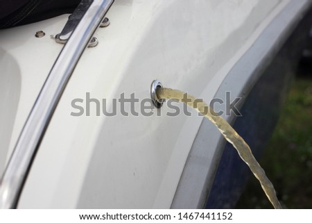 Vessel bilge pump removes water from boat through drain scupper in Board Royalty-Free Stock Photo #1467441152