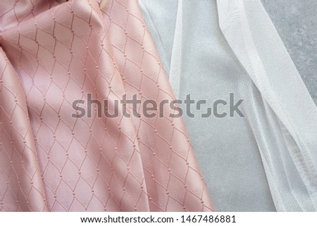 Fabric samples on the table. The designer workplace concept. Freelance fashion comfortable femininity workspace in flat lay style on gray background. Top view