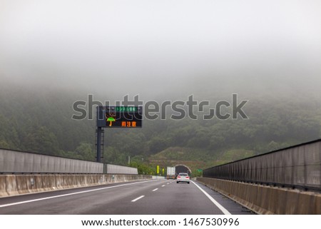 Driving on the high way at moody foggy landscape view.