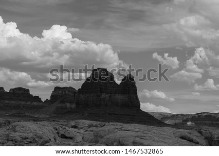 Black and white landscape of large rock formation or hill against clouds - Hite, Utah in Glen Canyon National Recreation Area