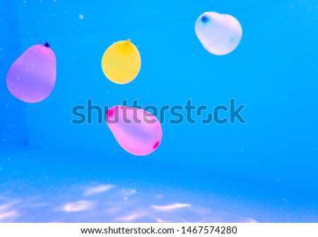 Florence, Italy, 2019. Colorful balloons float in the water of a swimming pool in Tuscany