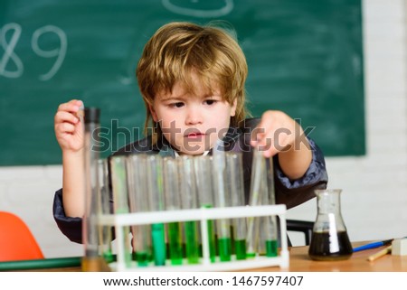 small boy using microscope at school lesson. small boy study chemistry. result. Medical concept. Little genius child. testing tubes with liquid for research. learn for future. Research development.