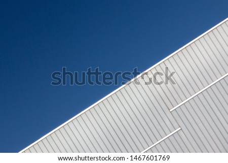 Futuristic White Building With Geometric Lines Against a Clear Blue Sky