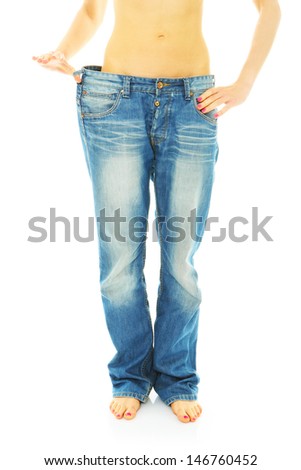 A picture of a young woman in loose jeans showing effects of diet over white background