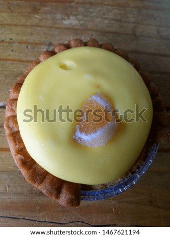 Lemon tart with yellow icing and lemon jelly decorated 