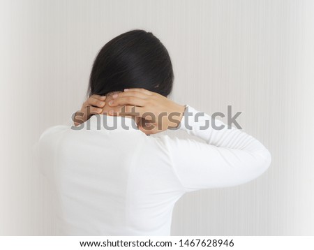 cervical spondylitis, neck sprain,fibromyalgia and osteomyelitis in asian woman. She use hand touching neck back on isolated white background use for health care concept.