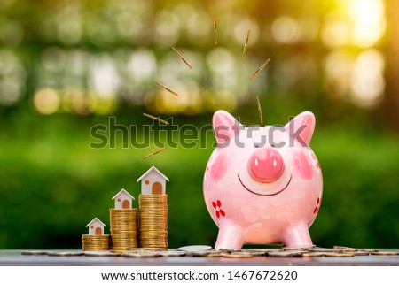 Piggy bank and coin drop on the top with working capital management and home model is destination put on the wood in the public park, Loan and business investment with real estate for future concept.