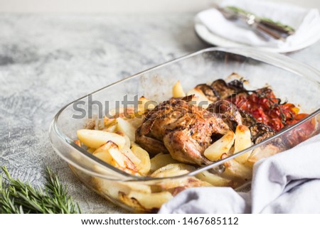 Baked whole chicken with potatoes, eggplant and cherry tomatoes. healthy dinner.