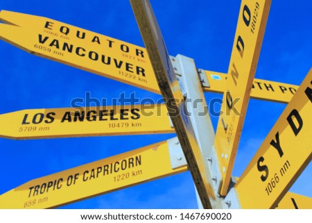 Yellow Signboard with directions and distance to Los Angeles, Vancouver, the Equator, Sydney, London