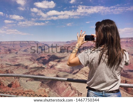 Girl taking a picture with her mobile in the Grand Canyon of the Colorado.