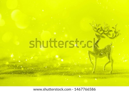 Silver glitter Christmas deer on neon yellow background with lights bokeh, copy space. Greeting card for new year party. Festive holiday concept. Banner.