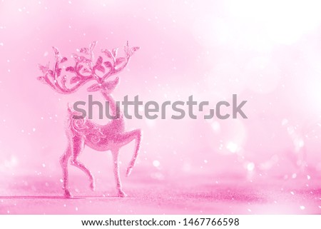 Silver glitter Christmas deer on neon pink background with lights bokeh, copy space. Greeting card for new year party. Festive holiday concept. Banner.