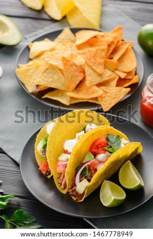 Hard-shell tacos and nachos. Crispy tortilla with tasty filling, served with lime and salsa dip. Famous Mexican snacks and dish.