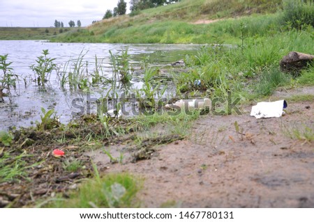 Garbage left by a man lies near a reservoir.