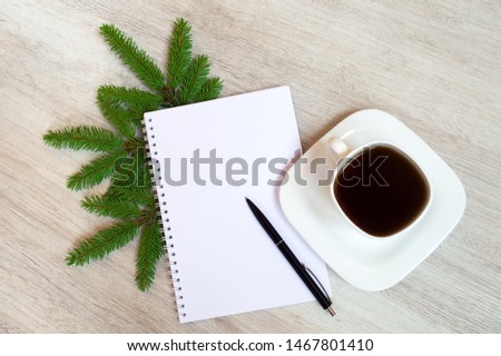 Christmas composition from  notebook, pen, coffee cup and fir dranches on wooden background,  place for text. Christmas, winter, new year concept. Flat lay, top view, copy space