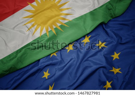 waving colorful flag of european union and flag of kurdistan.macro