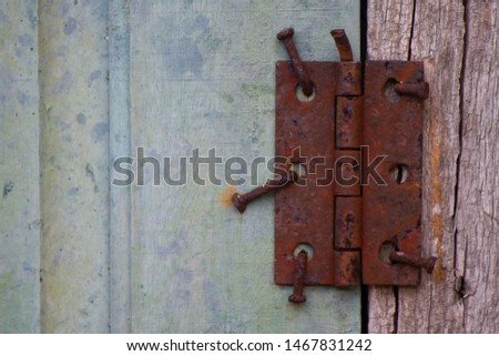 Detail on a completely rusty hinge and fastened to the wooden window with long nails Royalty-Free Stock Photo #1467831242