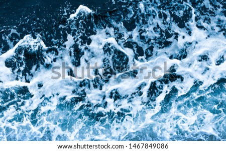 Background shot of aqua sea water waves surface. Blue ocean water and foam aerial or drone photo.