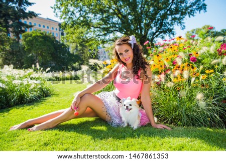 Beautiful girl with a small dog Chihuahua in the park