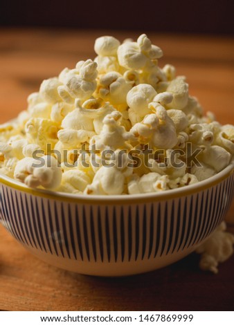 Close up of fresh popcorn in a bowl on a wooden table