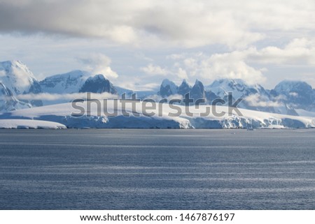 Snow-capped mountains and icy shores of the Lemaire Channel in the Antarctic Peninsula, Antarctica