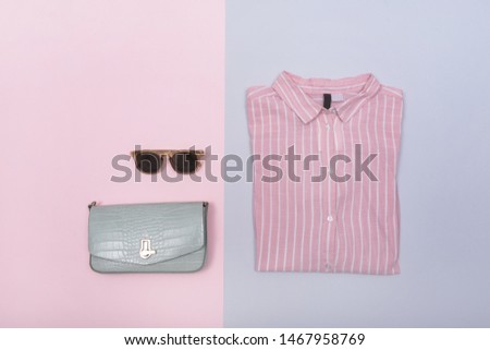 Fashion Woman Accessories Set ,folded striped shirt and gray clutch ,sunglasses on pink ,gray, blue background


