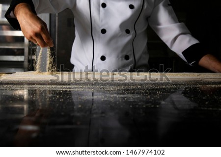 Chef putting pistachio on black table