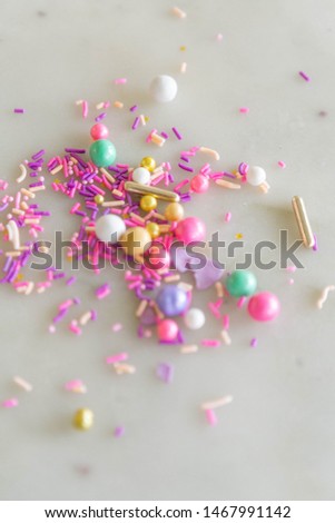 Colorful Sprinkles on Marble Background, scattered cookie and cake decorations
