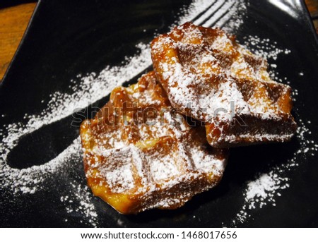 a Belgian waffle sprinkled with sugar.