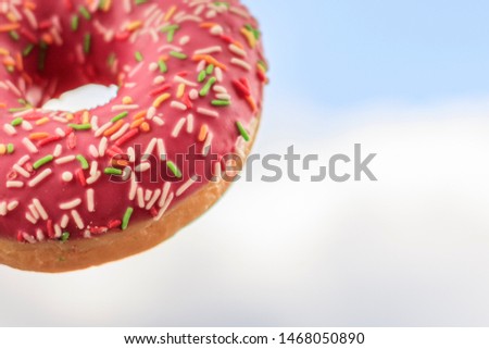 Donut with pink icing and pastry shavings. Confectionery. Traditional American Dainty