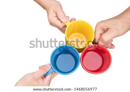 Top view image of three people clinking coffee cups red, yellow, blue on white blackground with a path
