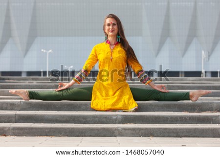 Pretty woman doing yoga exercises in the park. Portrait.