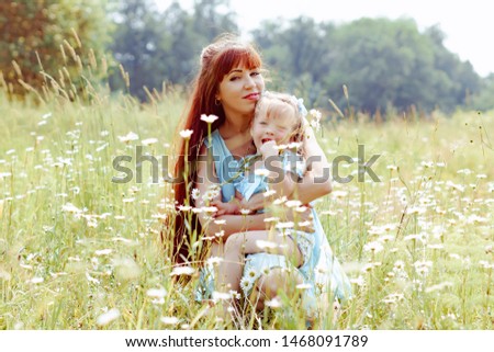 mom hugs her daughter in nature