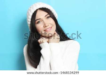 Beautiful girl in a warm cozy sweater on a colored background.
