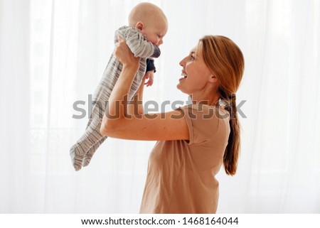 happy family mother playing with newborn baby at home white background