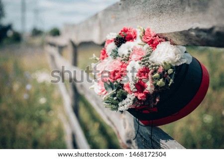 A bouquet of flowers in the shape of a heart on a wooden fence.