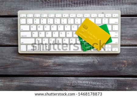 Pay by card concept and keyboard on wooden background top view