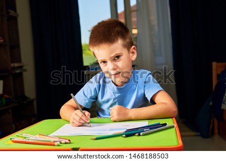 Little boy drawing greeting card on table. Father's day concept