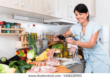 Glad cheerful  smiling  female is photo food that she buying in the market grocery indoor.