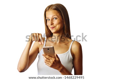 Happy smiling young woman points at her smartphone with finger, isolated over white background