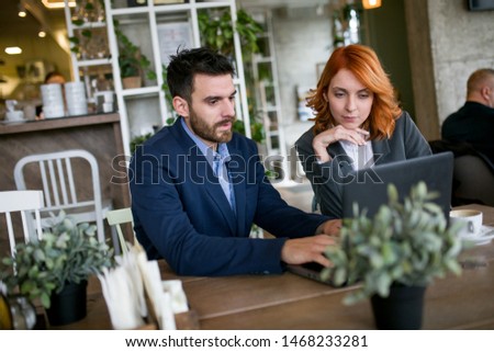 Handsome man talking to a young  woman at the cafe.Business concept.Talk about business.Man and woman with notebook.stock photo