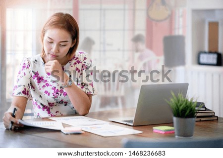Businesswoman working with chart and laptop in modern office.