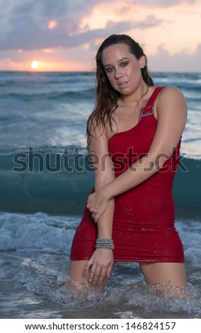 Model at the beach in a red dress
